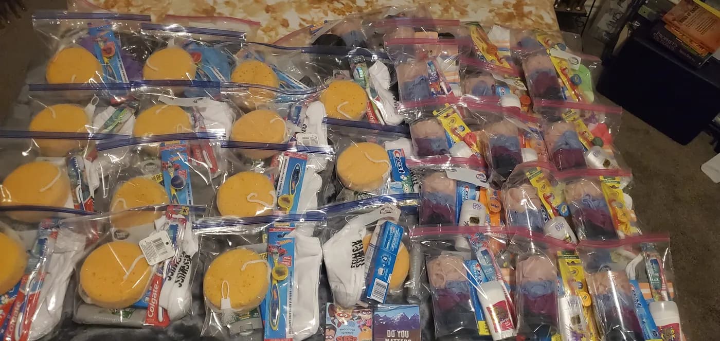 Rows of care kits with sponges, toothbrushes, and toiletries