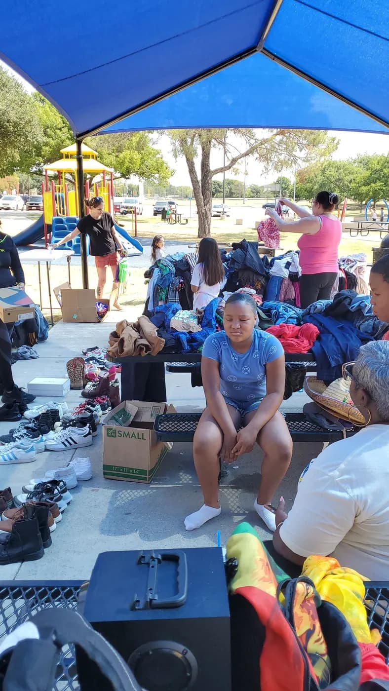 Tables of donated clothing and shoes at an outdoor giveaway